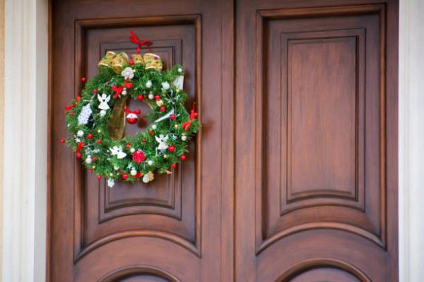 Decorar puerta en Navidad con corona de adornos