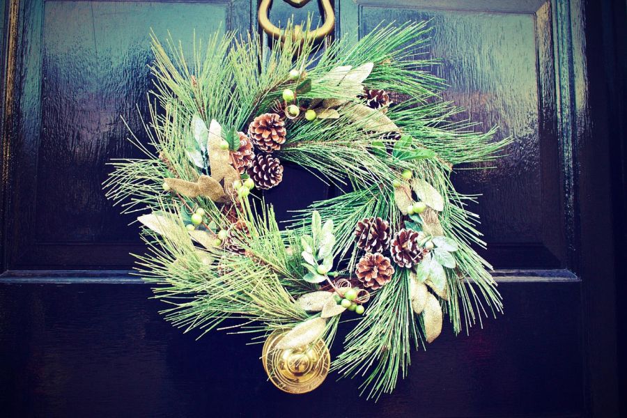 Decorar puerta en Navidad con corona de piñas y pino