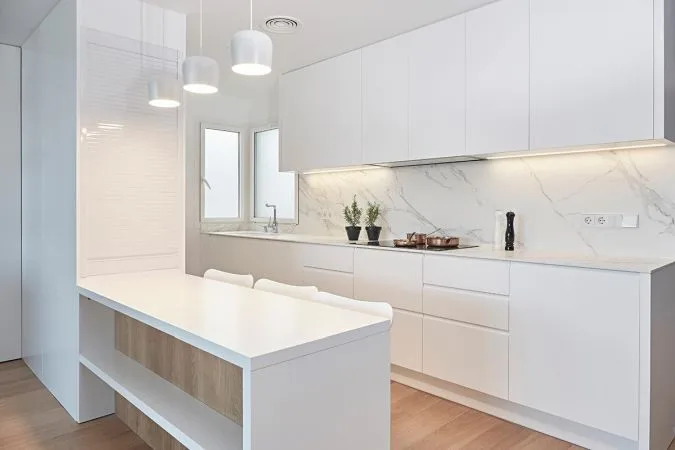Cocina integral en blanco paredes de mármol