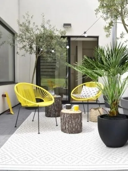 Terraza moderna sillas amarillas y tocones de madera