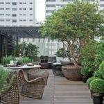 Terraza moderna abierta con arboles en maceta y muebles de madera
