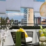 Terraza cerrada con vidrios y cortinas interiores verticales