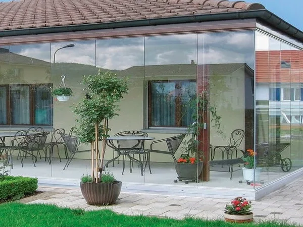 Terraza moderna cerrada con cortina de vidrio