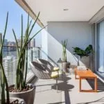 Terraza moderna techada con plantas y mobiliario de madera