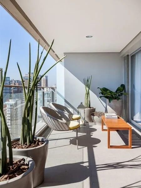 Terraza moderna techada con plantas y
mobiliario de madera
