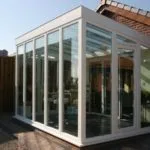 Terraza moderna cerrada con policarbonato y perfiles blancos