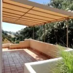 Terraza moderna con techo de lona con armazon fija