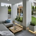 Terraza moderna techada y muebles en L y columnas atemporales