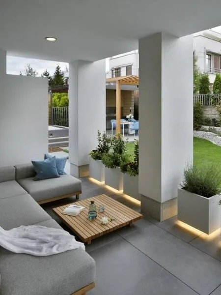 Terraza moderna techada y muebles en L y columnas atemporales