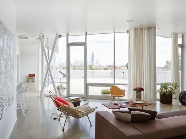 Casa moderna con mucha iluminacion que entra por las enormes ventanas