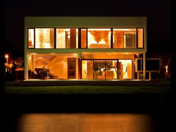 Fachada de casa moderna y bonita con forma cuadrada y vista nocturna