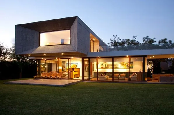 Fachada de casa moderna y bonita con balcon saliente en vista nocturna