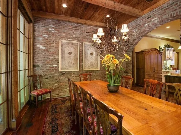 comedor con pared focal de ladrillo con cuadros de pinturas
