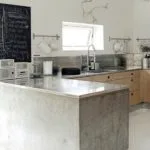 Cocina de cemento pulido y madera en L con amplia encimera