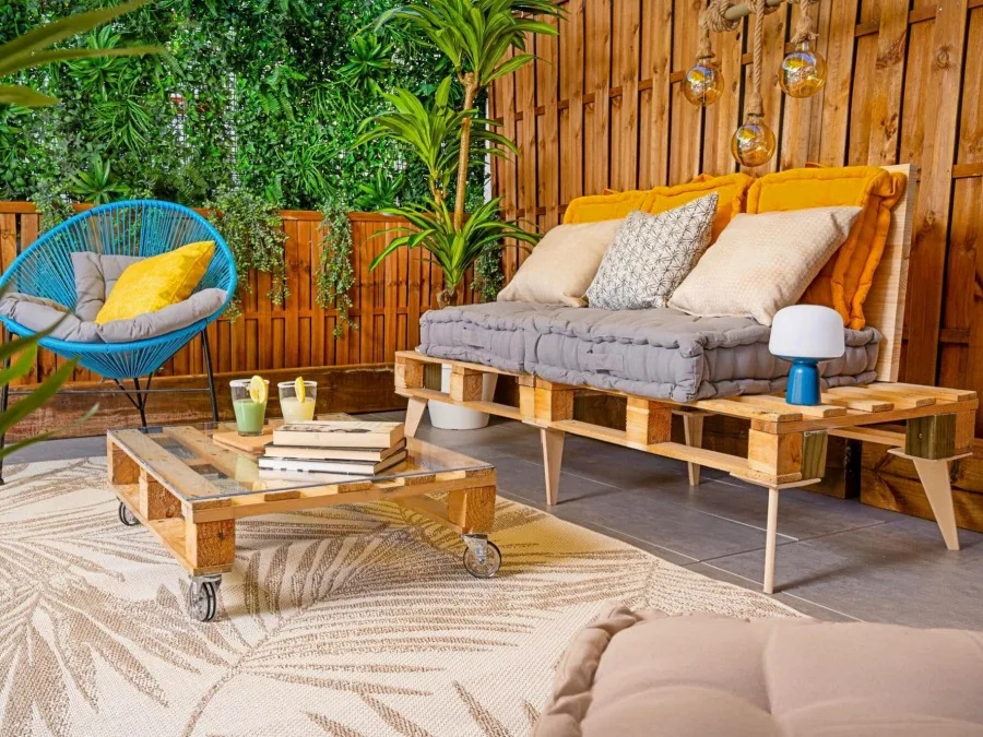 Sofá de pallets y mesa con cristal en Patio interior. 
