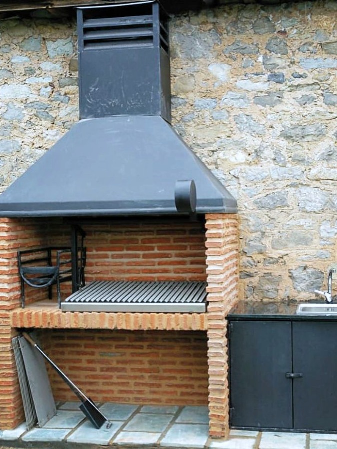 Asador de ladrillo con chimenea metálica negra moderna