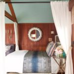 Dormitorio clásico romántico con pared celeste y paneles de madera oscuros