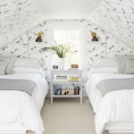 Dormitorio en buhardilla con paredes blancas y aves pintadas