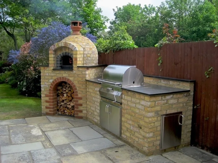 Asador de ladrillos estilo mediterráneo con un toque moderno con nevera y parrilla en acero inoxidable