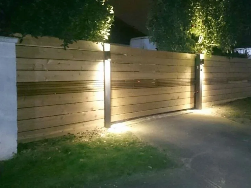 Barda de bloque con paneles de madera e iluminación en doble dirección