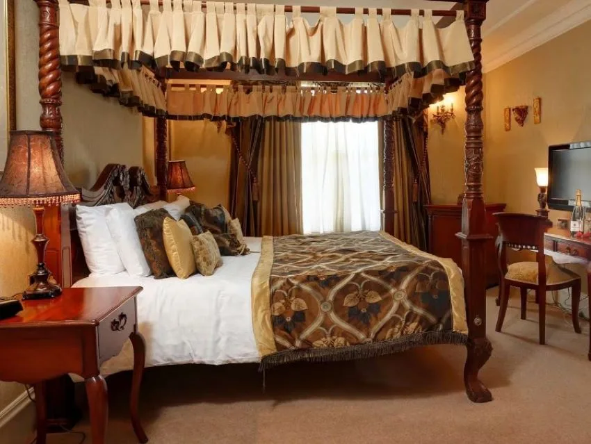 cama clasica de madera con parte corta de cortina en el dosel