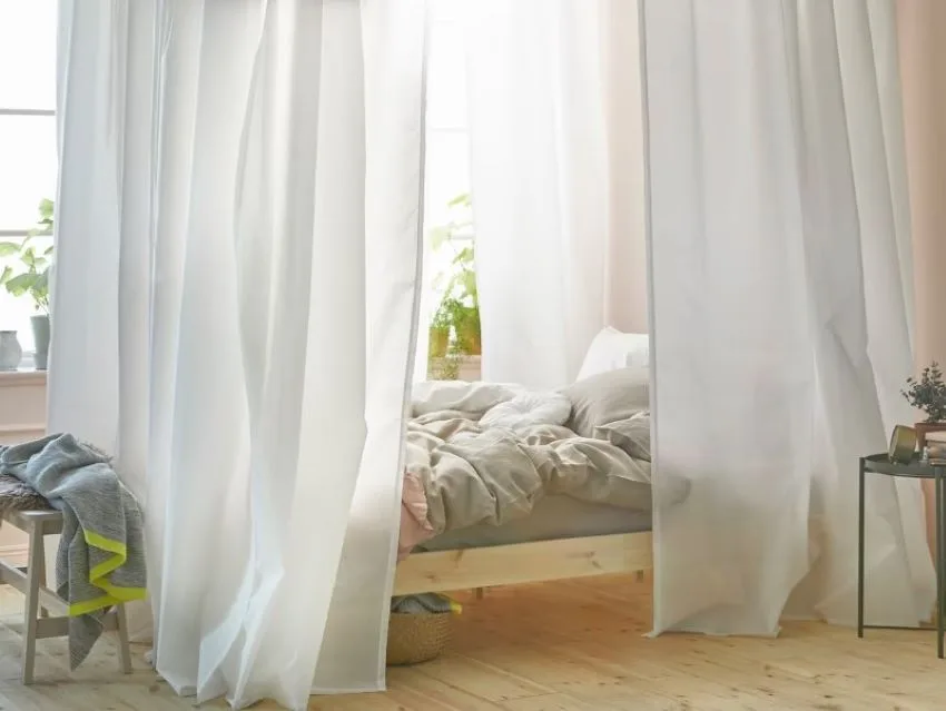 cama clasica de madera con cortinas blancas semi transparentes