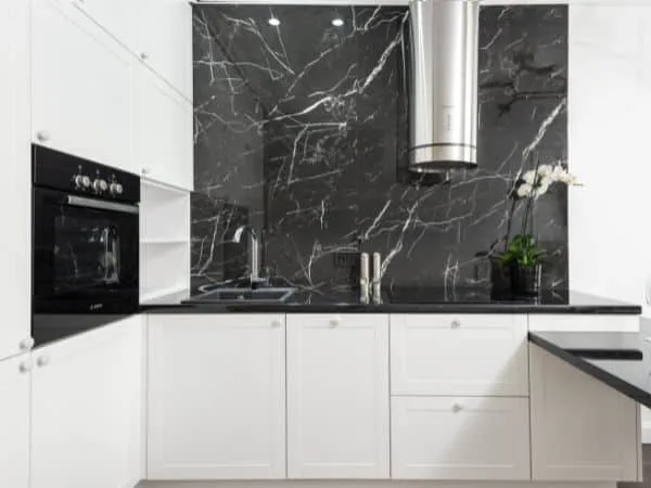 cocina moderna blanca con microondas integrado frontal de marmol y extractor de diseño