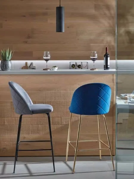 cocina moderna con frontal e isla de madera clara y taburetes de terciopelo
