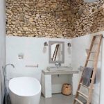 Baños rústicos con pared de piedra