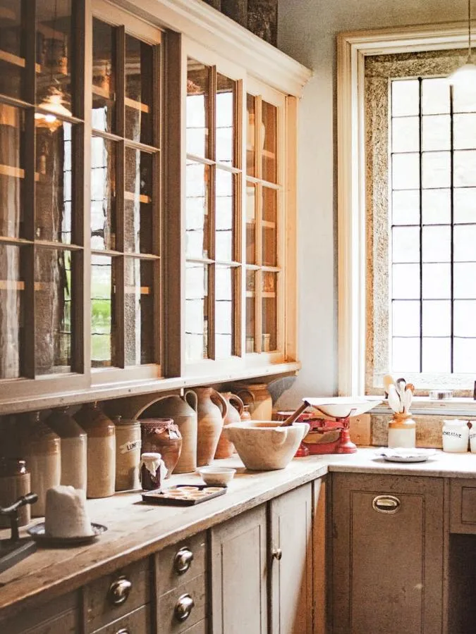 Cocina rustica de madera estilo botica con tiradores de metal y muchas piezas de artesania