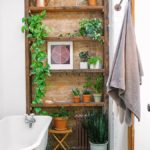 Baño con un estante de madera decorado con plantas y macetas